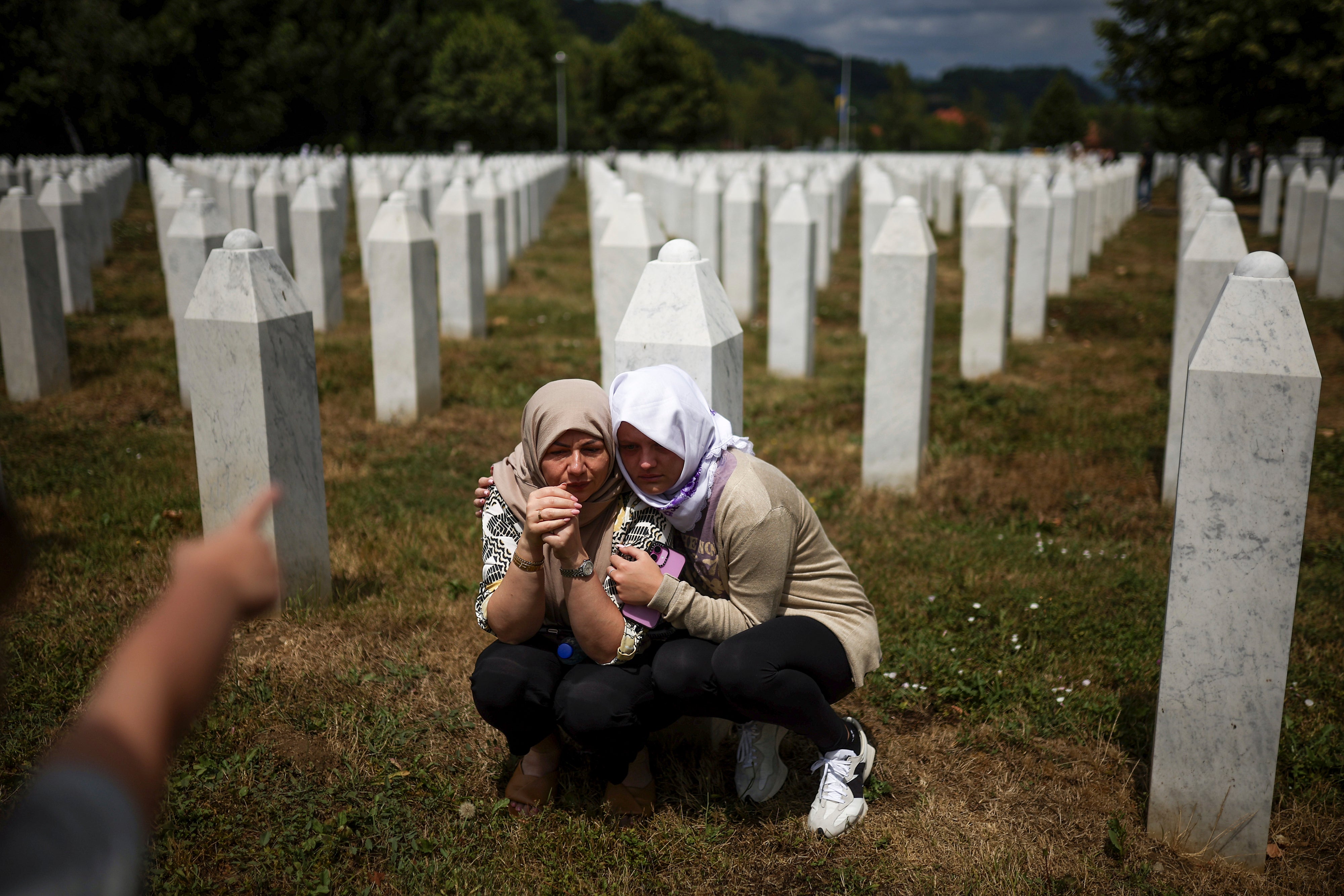 Članovi obitelji tuguju pored groba njihovog rođaka, žrtva Srebrenica genocida