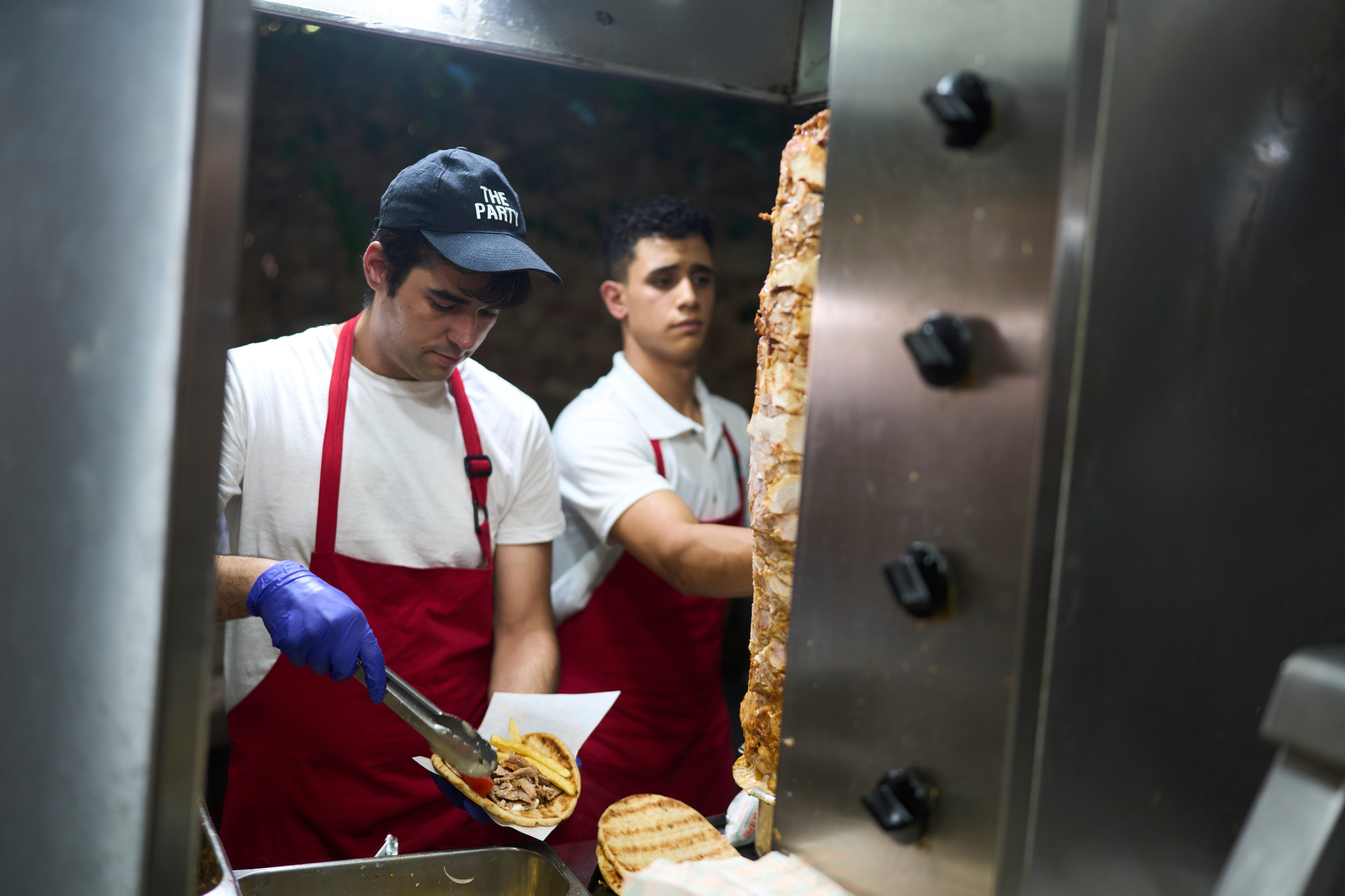 Grill Cook Thomas Simandas pravi tradicionalni Souvraki u restoranu u središnjem okrugu Monastiraki tijekom vrućeg dana u Ateni u srijedu, 16. srpnja 2025. (AP Photo/Petros Giannakouris)