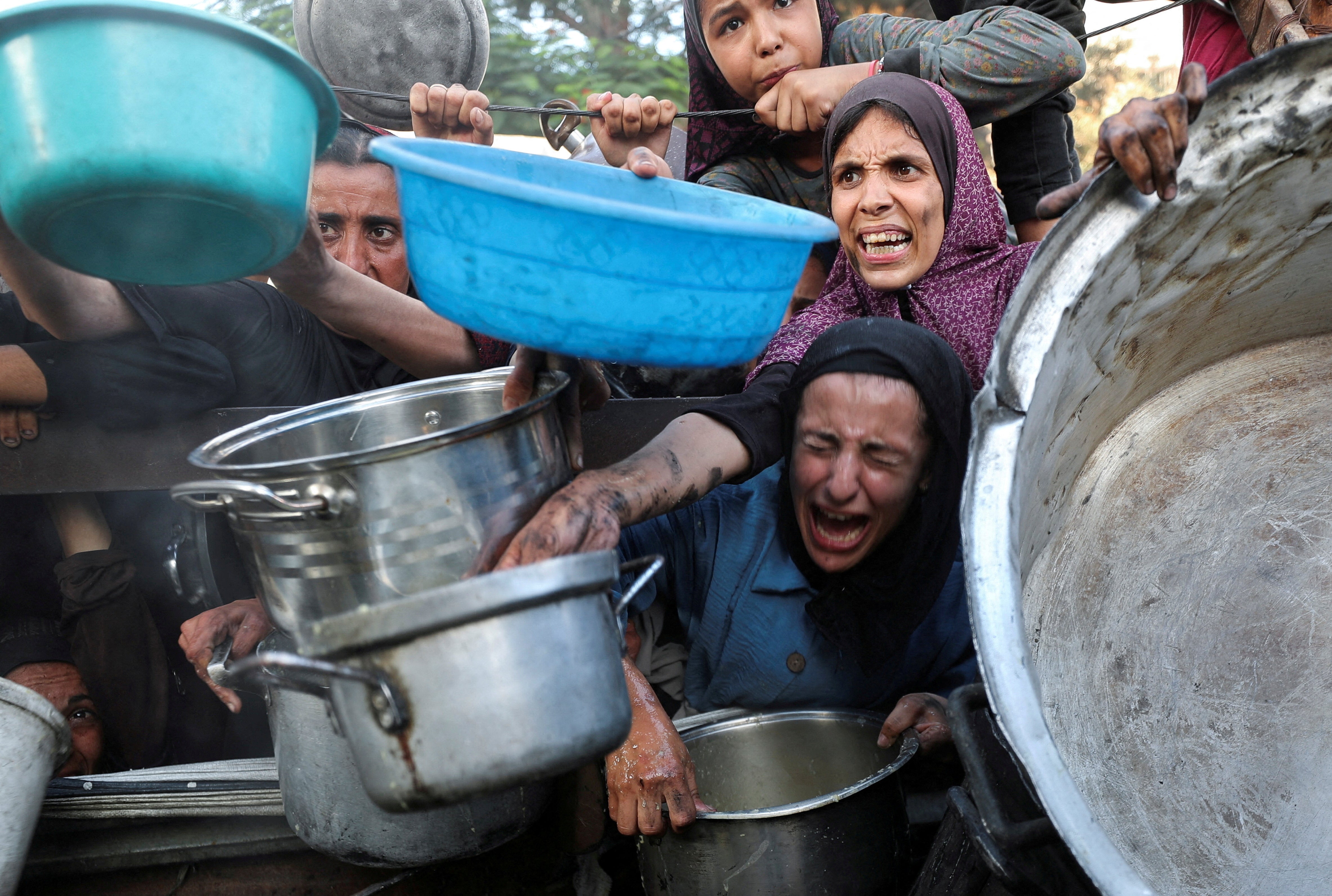 Palestinci traže hranu iz dobrotvorne kuhinje, usred krize gladi, u gradu Gaza