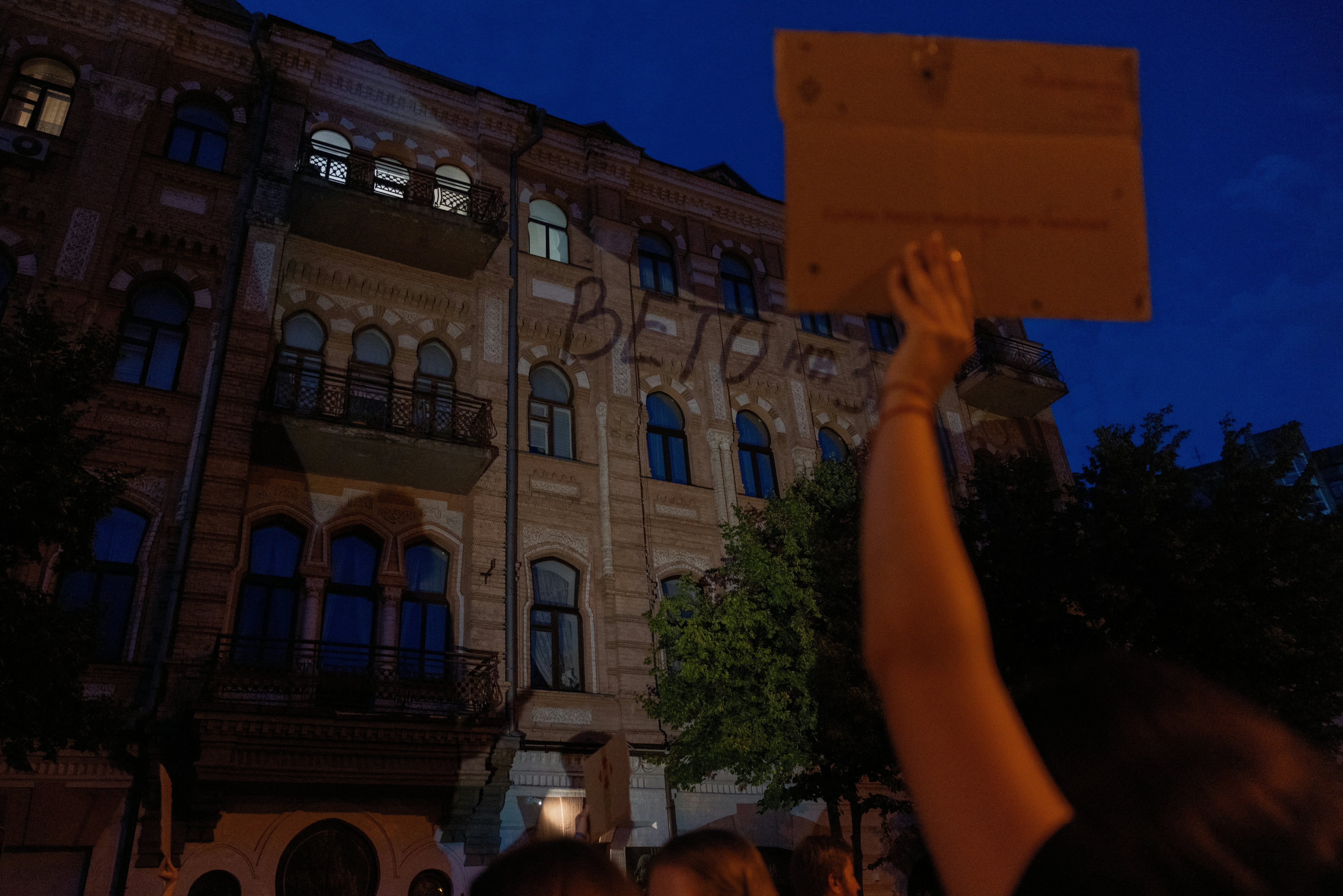 Ova fotografija prikazuje projekciju koja čita 'veto zakona' na građevinskoj fasadi tijekom demonstracije koja poziva ukrajinskog predsjednika da veto na zakon