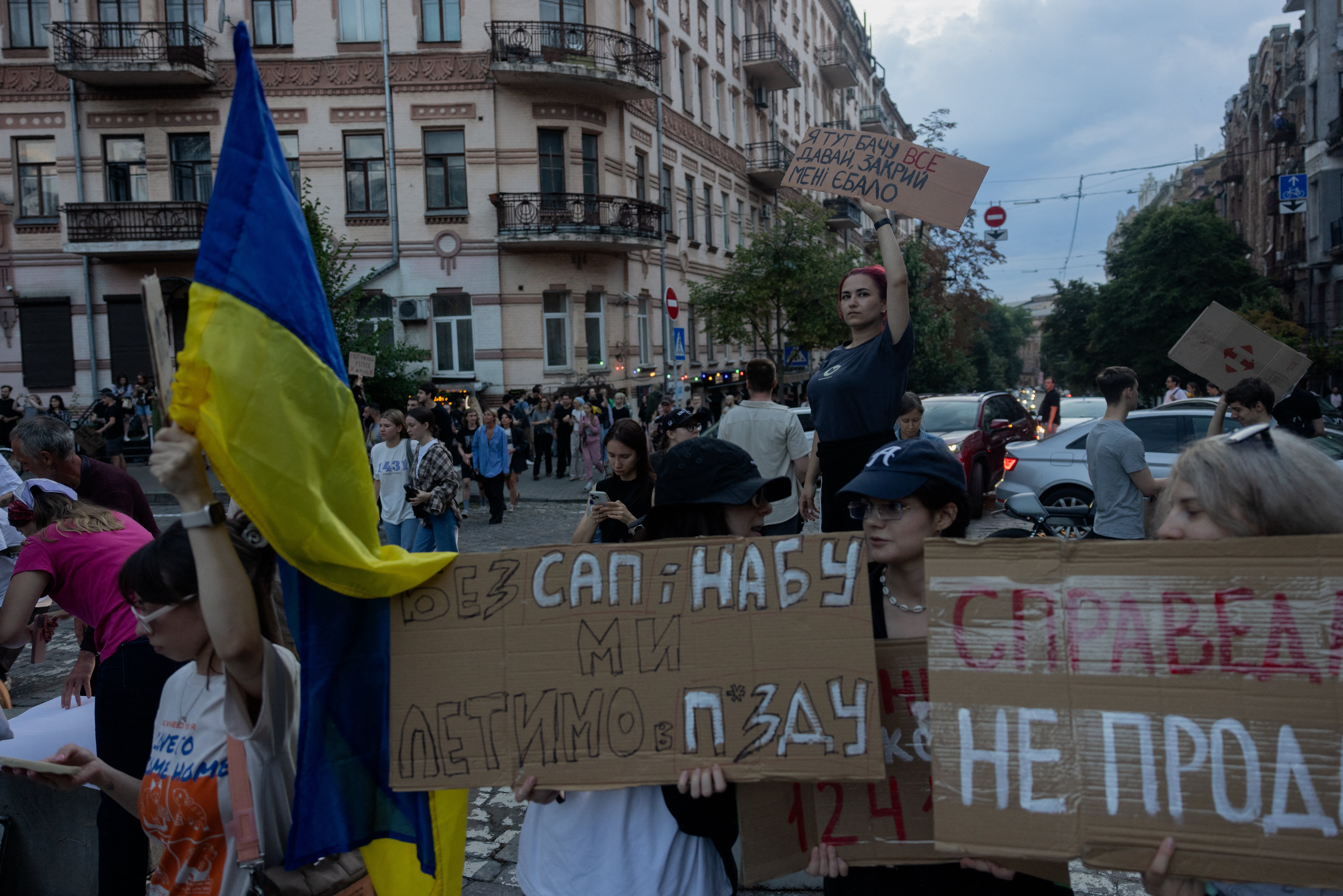 Prosvjednici drže plakate tijekom demonstracije koje je ukrajinskog predsjednika naložio zakon koji je donio zakon koji je donio parlament koji smanjuje ovlasti Nacionalnog ureda za borbu protiv korupcije Ukrajine (NABU) i specijaliziranog tužiteljstva protiv korupcije (SAPO) u središtu Kiva