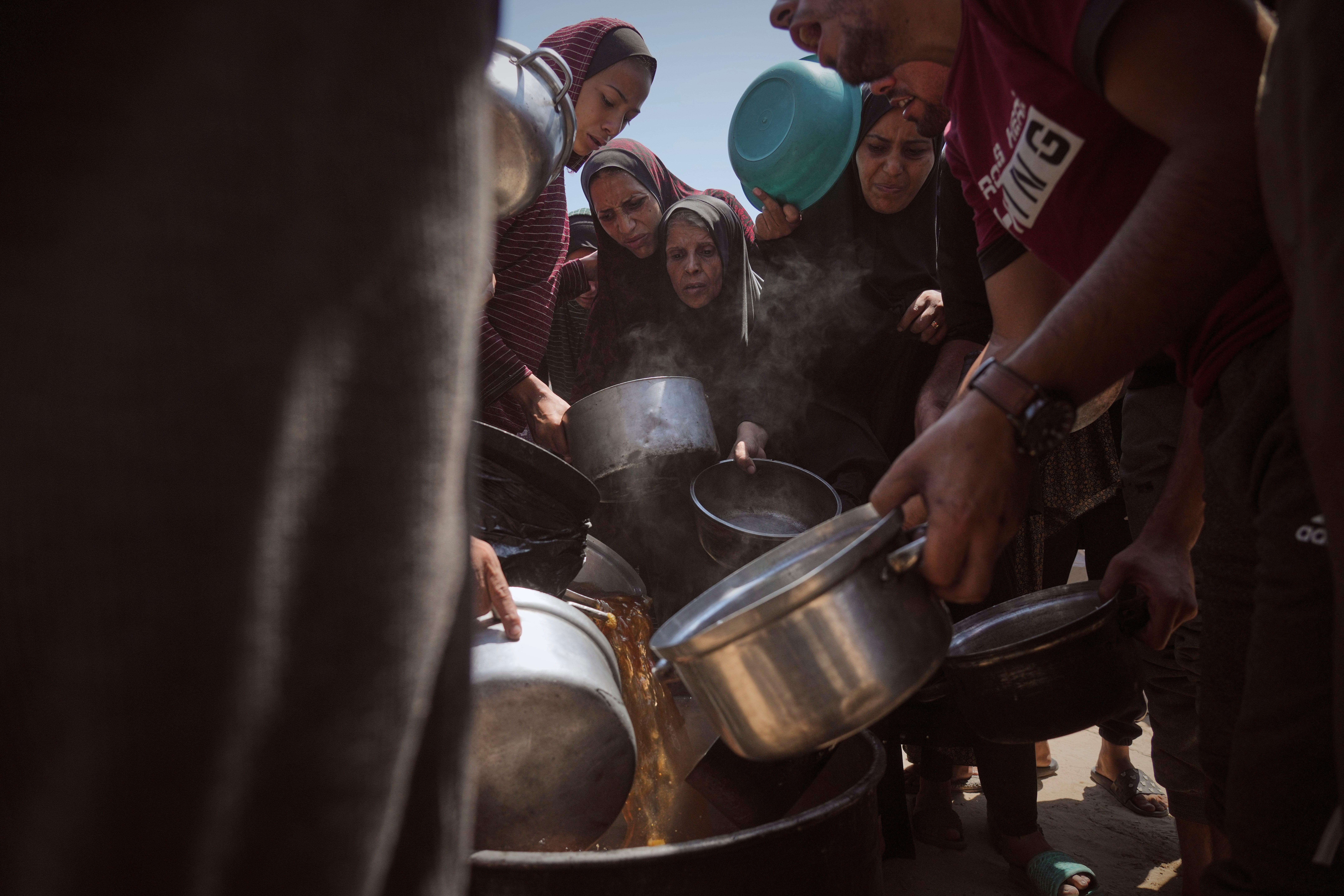 Raseljeni Palestinci dobivaju doniranu hranu u kuhinji zajednice u gradu Gaza, Strip na sjeveru Gaze
