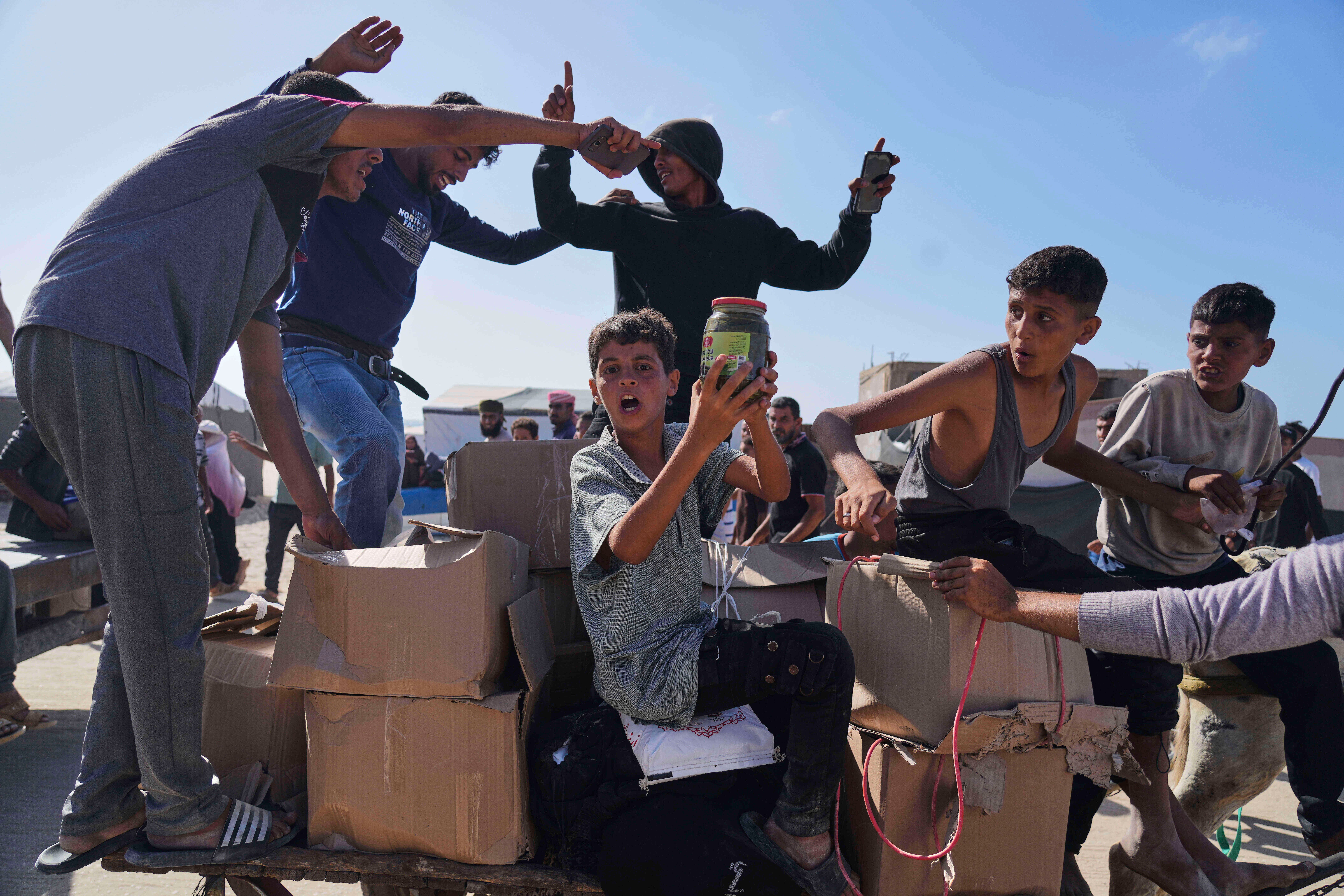 Palestinci nose kutije koje sadrže pakete hrane i humanitarne pomoći koje je isporučila Humanitarna zaklada u Gazi, organizacija podržana SAD-om koju je odobrio Izrael u Rafahu