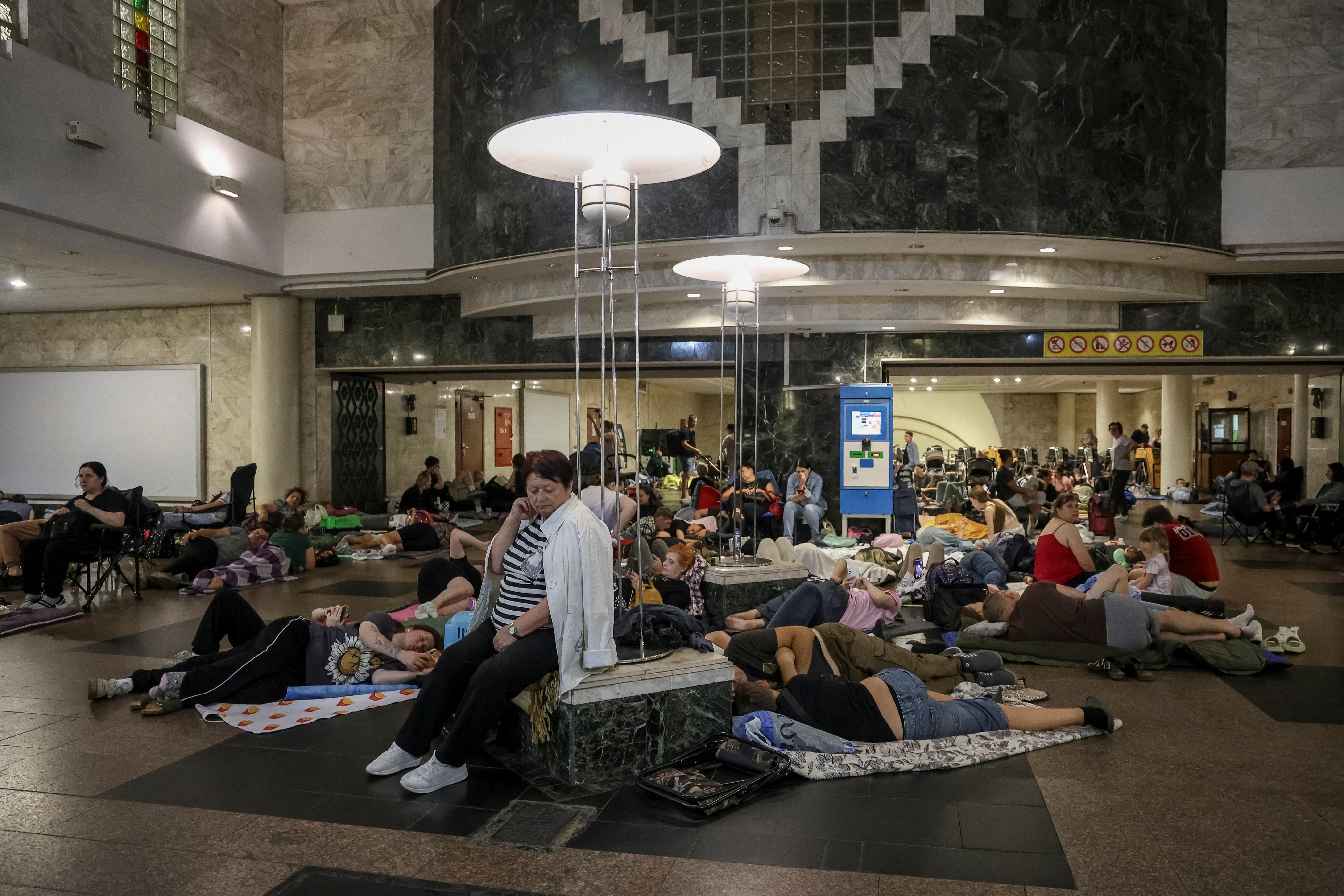 Ljudi se sklone unutar stanice metroa tijekom ruskog štrajka drona