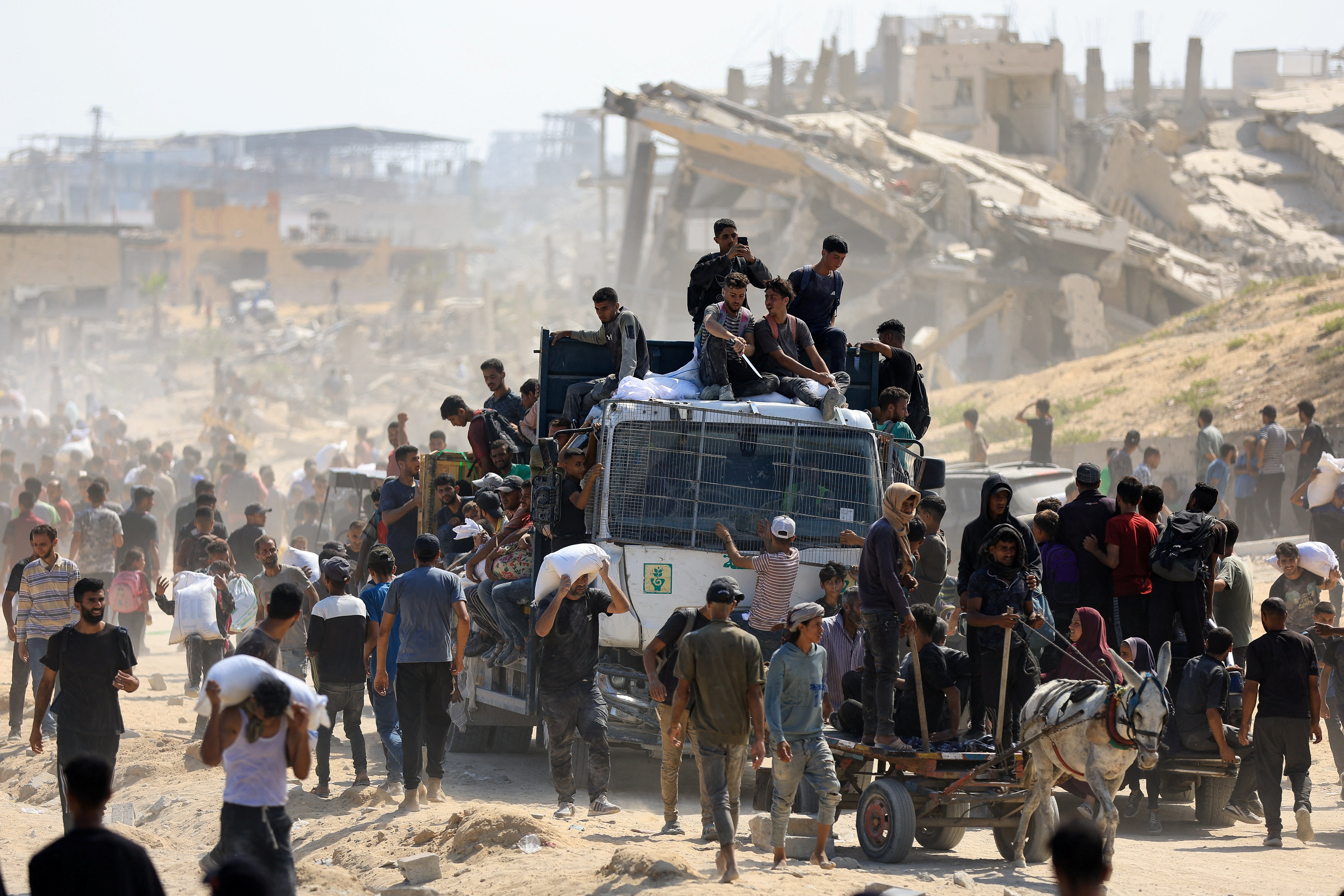 Palestinci se okupljaju dok traže zalihe pomoći koje su ušli u Gazu kroz Izrael u Beit Laha