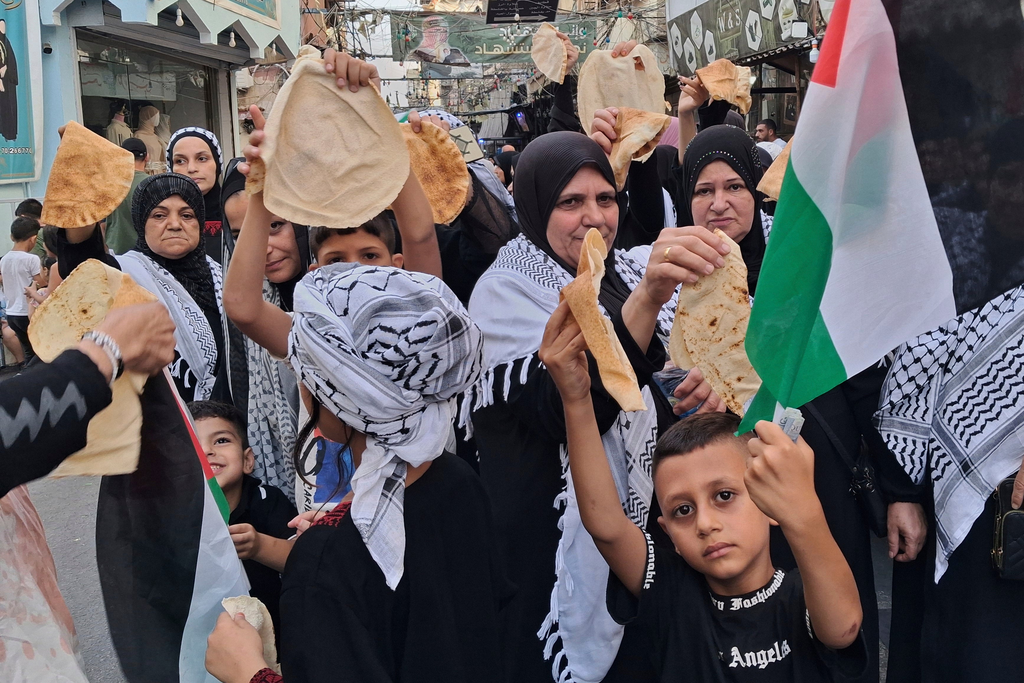 Palestinci drže komade kruha tijekom prosvjeda u izbjegličkom kampu Ein El-Hilweh u južnom lučkom gradu Sidon, Libanon, u nedjelju, 20. srpnja 2025., kao odgovor na globalni poziv na solidarnost s Palestincima tijekom rata Izraela protiv Hamasa u stripu Gaze i zabraniti Izraelski opsada