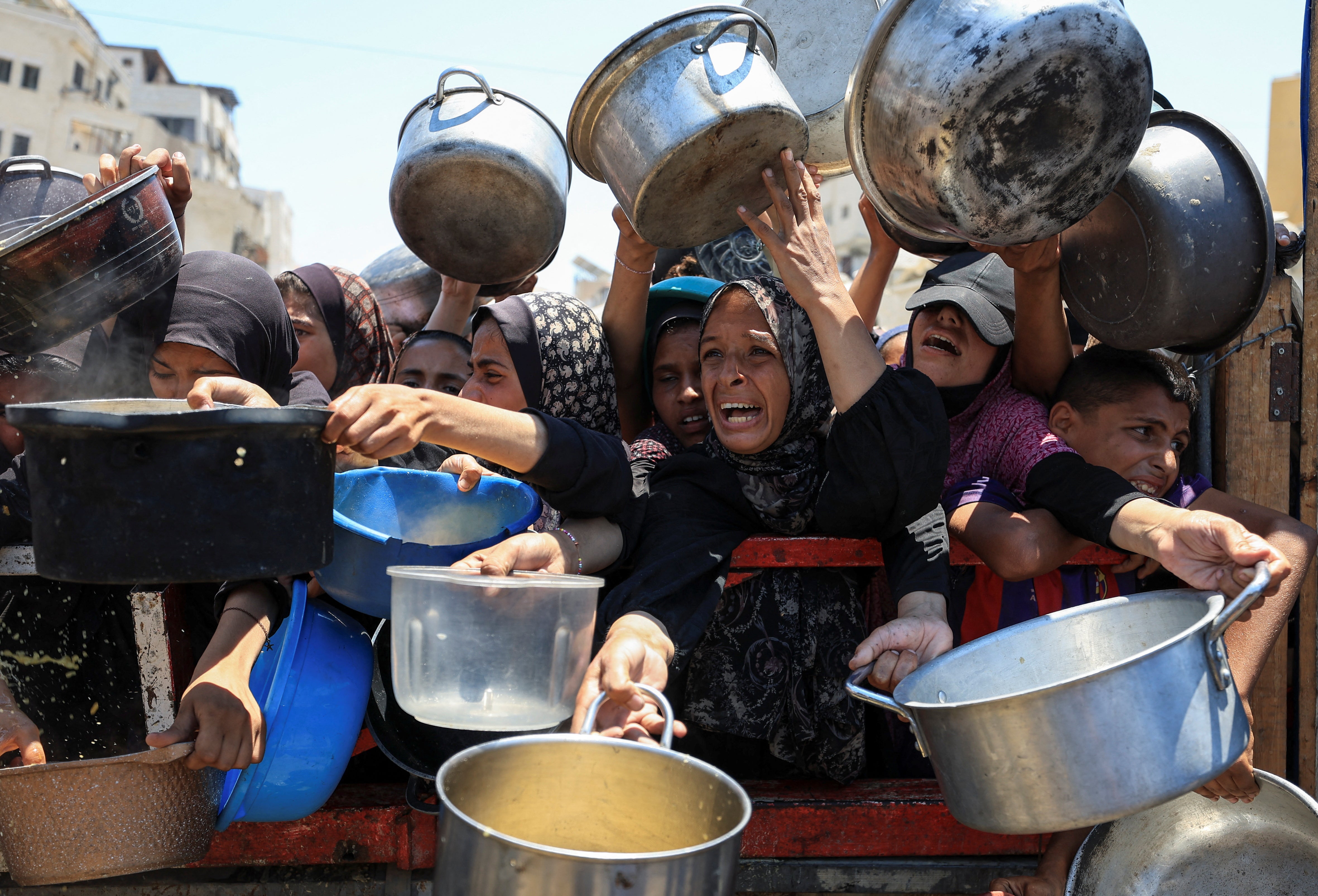 Palestinci se okupljaju kako bi primili hranu iz dobrotvorne kuhinje u Gazi