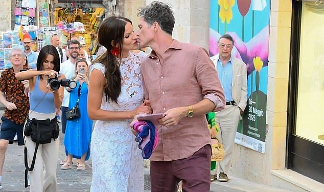 Stingova kći Fuchsia Kate Sumner vizija je u haljini za mladenke dok ljubi svog mladoženja tijekom ekstravagantnog prije vjenčanja ulice s talijanskim maršing bendom na Siciliji