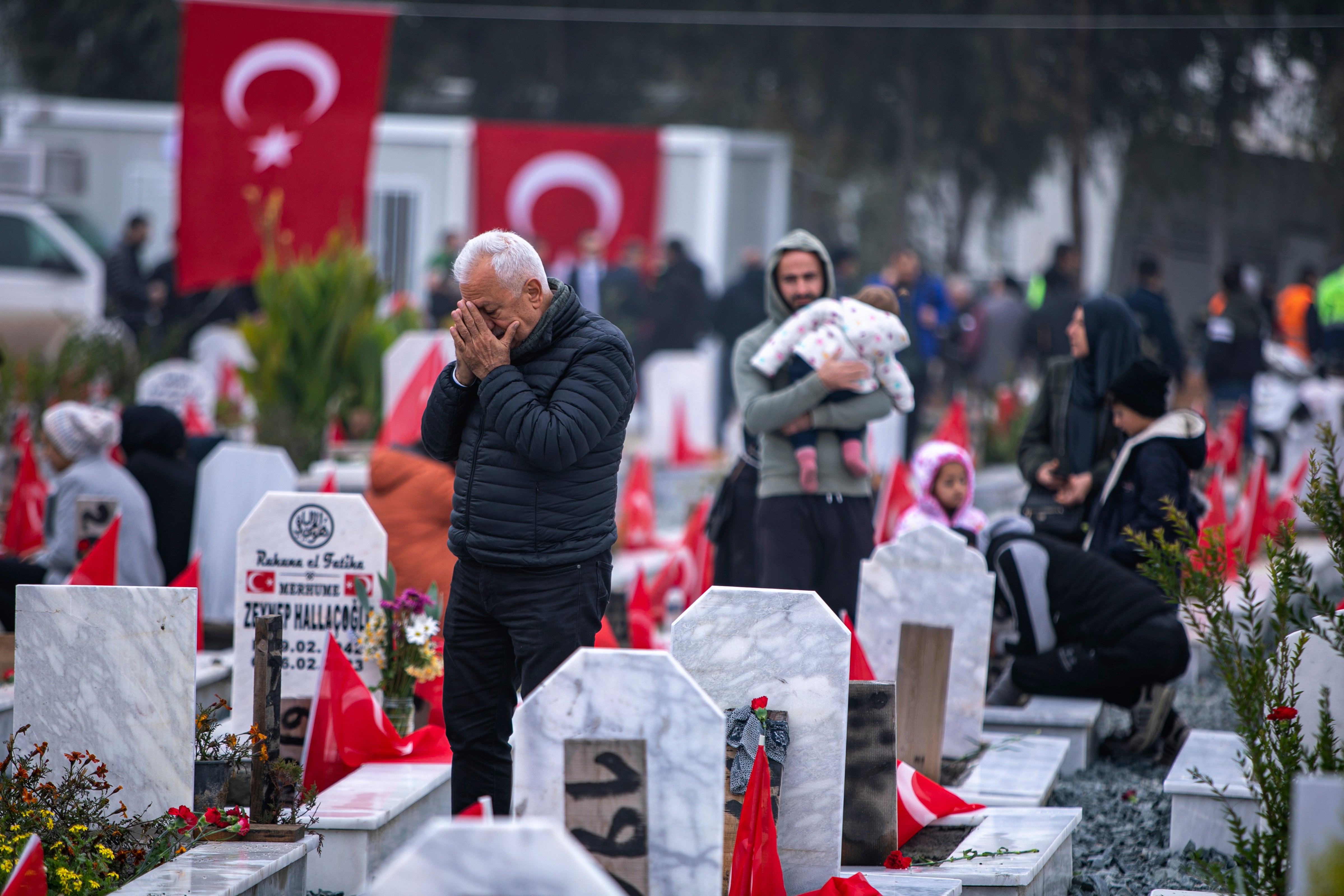 Datoteka Ljudi posjećuju grobove na groblju gdje su neke od žrtava potresa u veljači 2023. godine pokopane u Antakyi, Turska