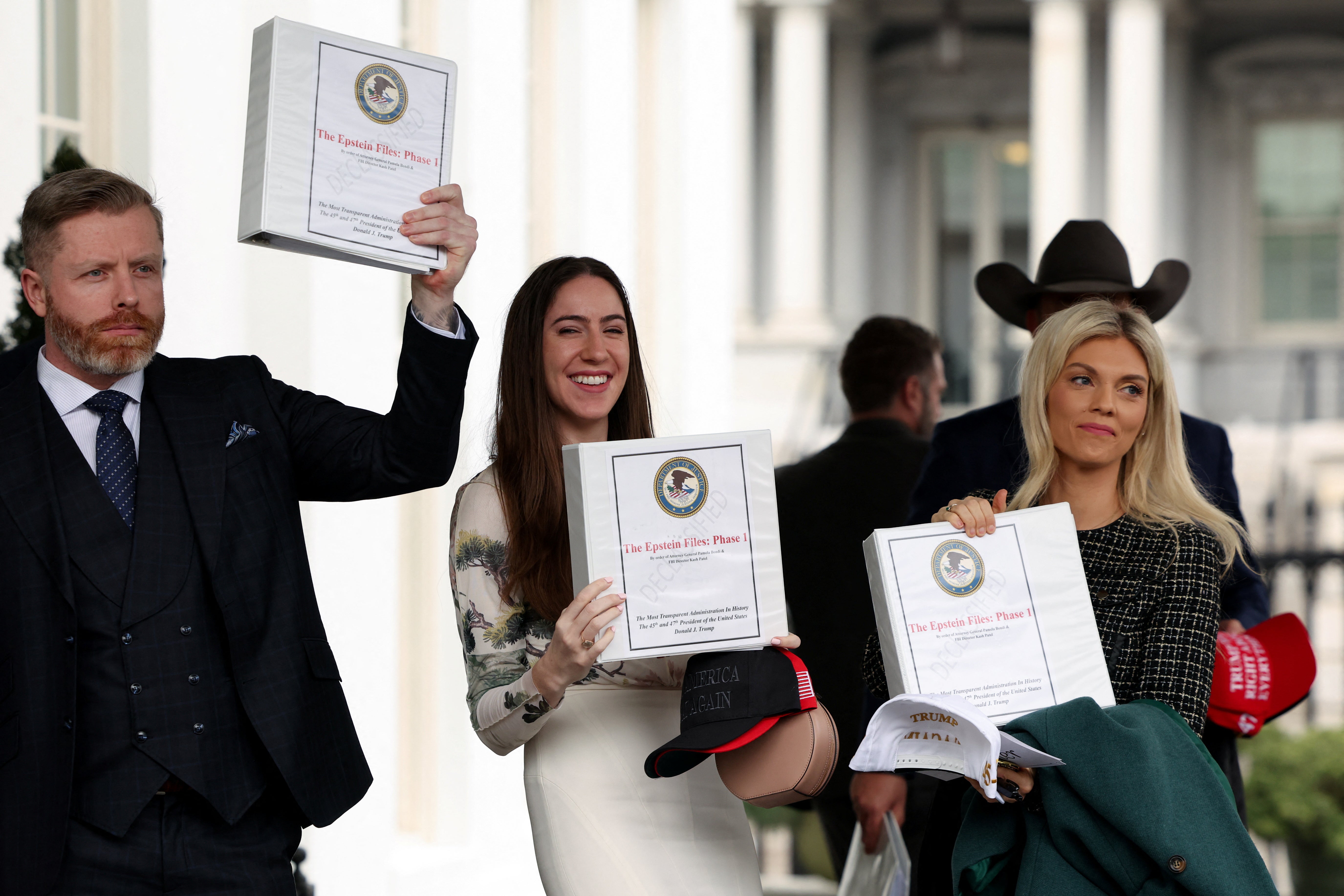 People walk out of the West Wing of the White House with