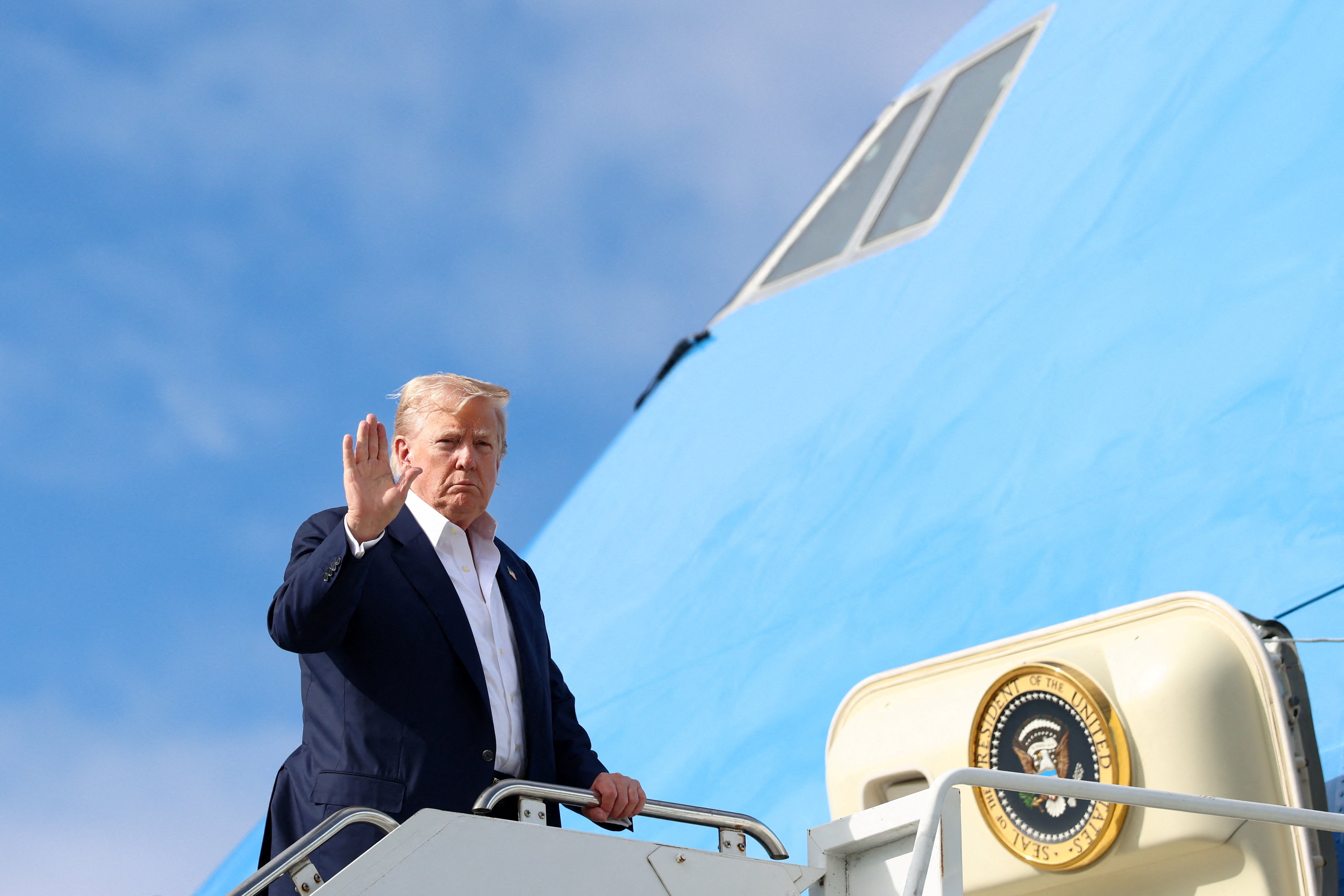 Američki predsjednik Donald Trump gestikulira dok se ukrcava u zrakoplovne snage dok se vraća u Washington, DC, u LossIemouth