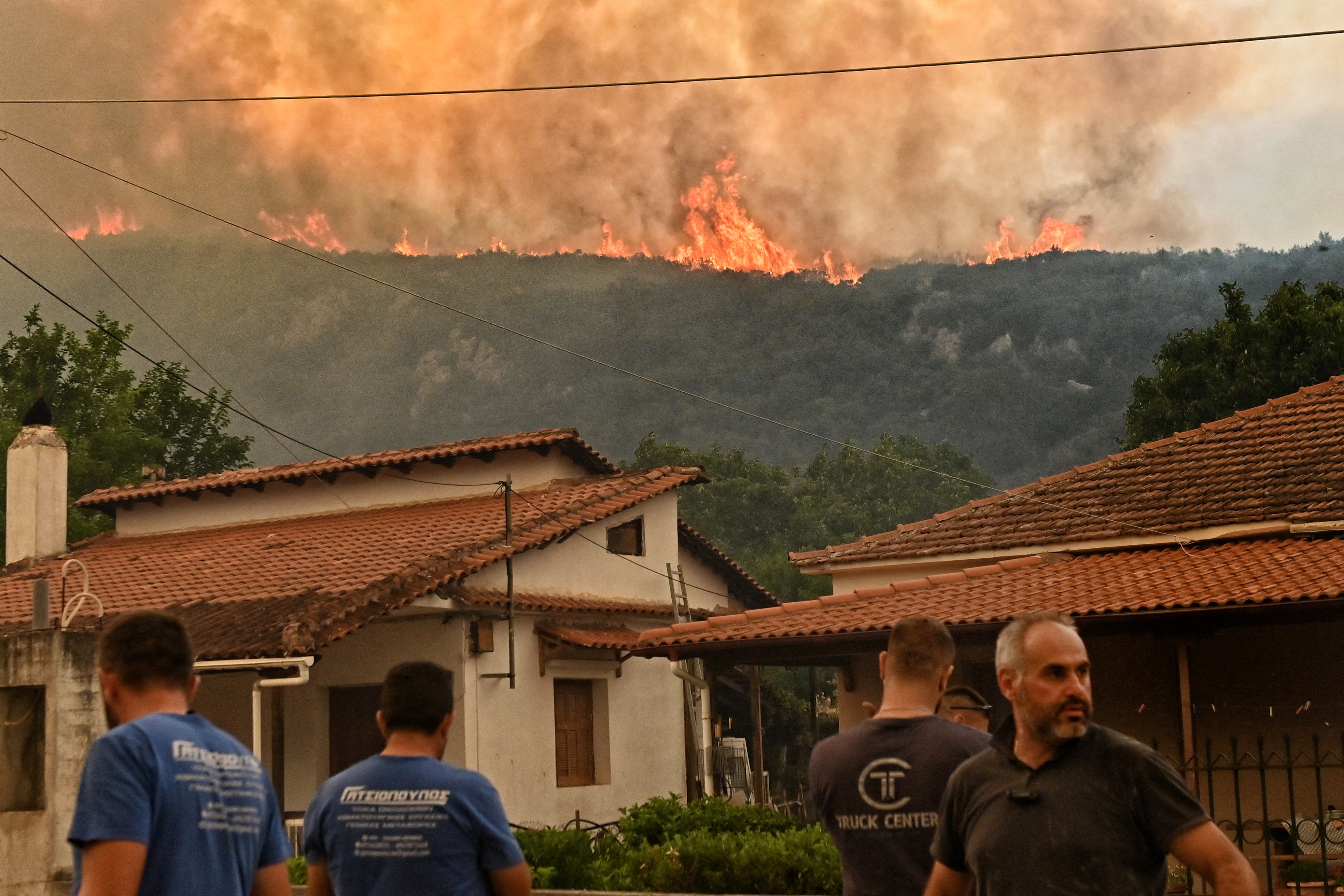 Stanovnici gledaju kako se plamen diže iz divlje vatre koji gori pored sela Karteri, u području Feneos, u blizini Korinta, Grčka, 22. srpnja 2025. Reuters/Vassilis Psomas