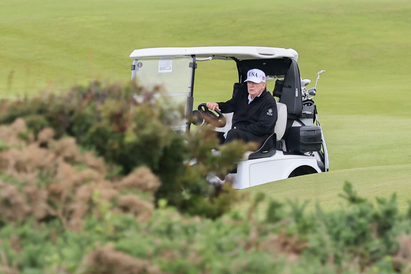 Američki predsjednik Donald Trump upravlja golf kolica u svom odmaralištu Trump Turnberry u Škotskoj (Robert Perry/PA)