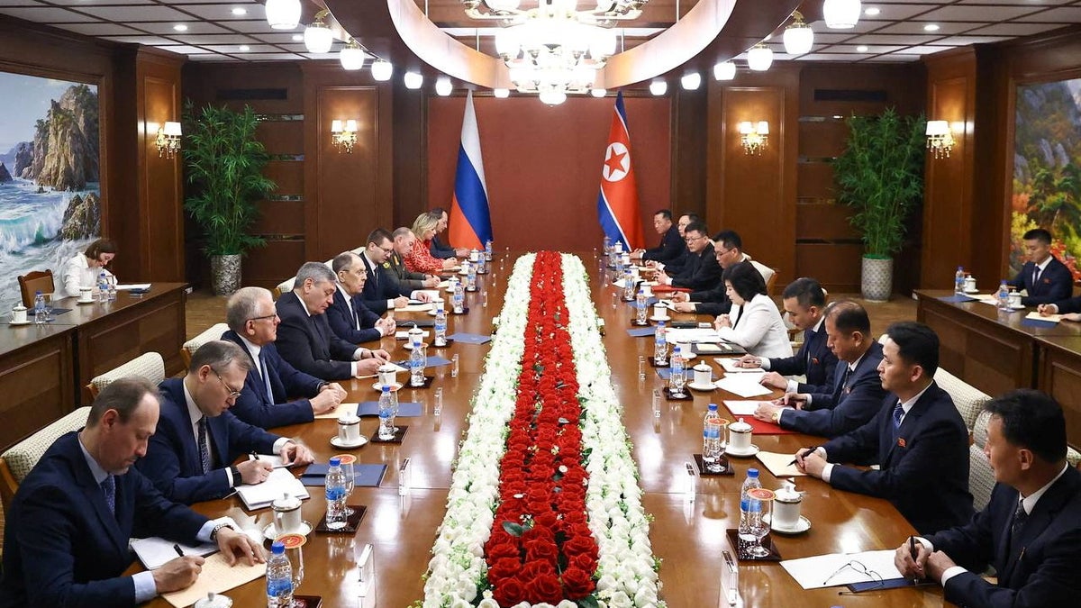 Sergej Levrov za stolom sa službenim mjestima u Sjevernoj Koreji