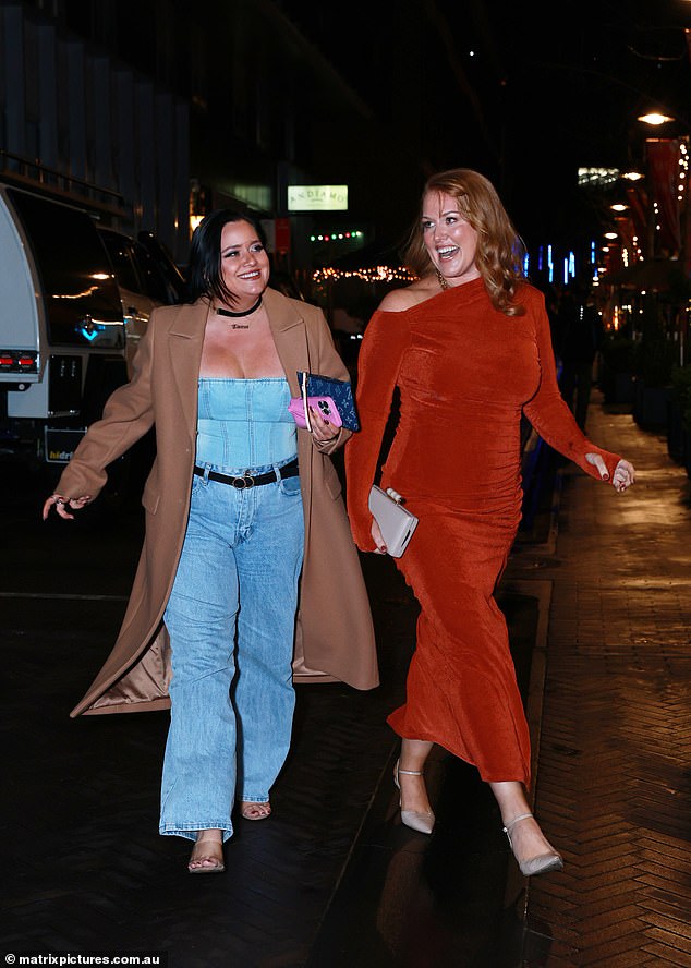 Katie je oblikovala svoju zlatnu kosu u mekim, bučnim kovrčama istrošenim, a šminka je bila bezvremenska