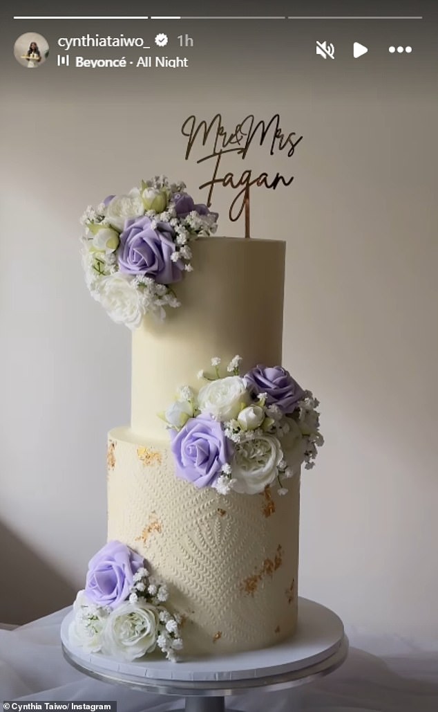 U međuvremenu, mladenci su ugurani u dvoslojni kolač s maslacem ukrašenim bijelim i jorgovanim cvjetovima