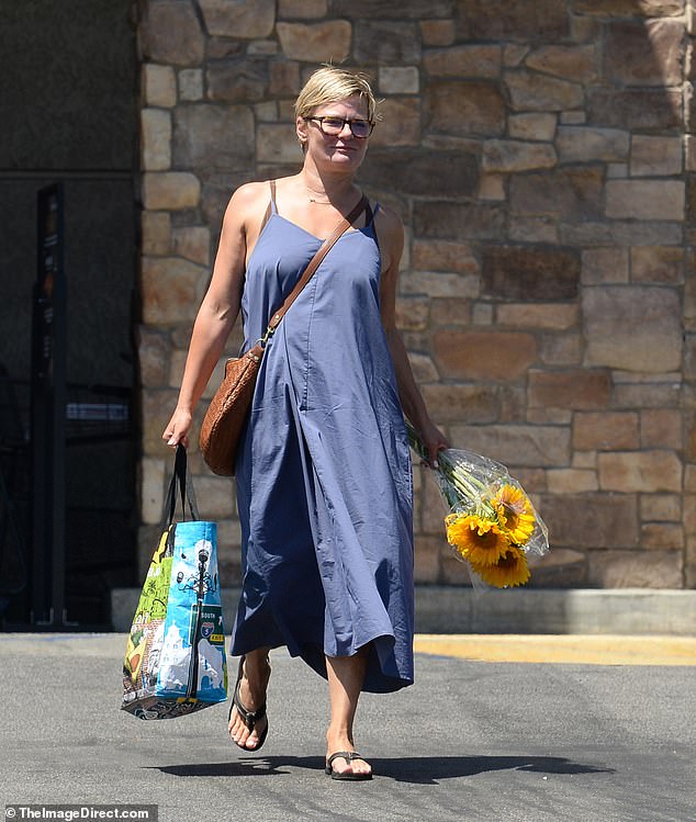 Navukla je plavu midi haljinu bez rukava zajedno s crnim sandalama za flip flop