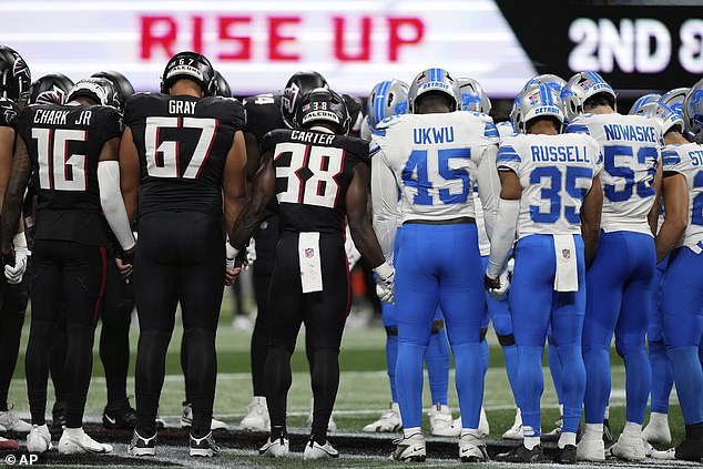 Igrači Atlanta Falcons i Detroit Lions stoje na terenu ruku pod ruku zajedno