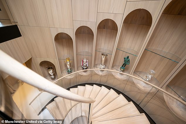 Spiralno stubište koje povezuje prizemlje s prvim katom obloženo je nekim od Unitedovih trofeja i poprsjem sir Matt Busbyja