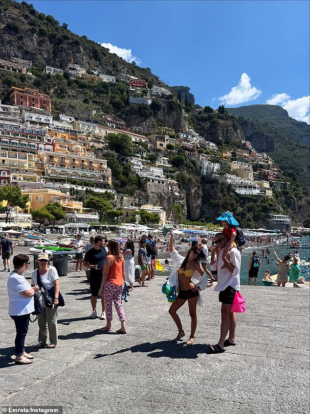 U drugim dnevnim pukotinama, viđena je kako pozira u jarko žutom vrhu bikinija i mikro kratkim hlačama dok su ona i prijatelj, za koje se činilo da nose sina na njegovim ramenima dok su stajali usred gomile turista, pozirali za kameru