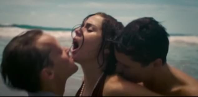 Također u novoj prikolici, zvijezda se vidi kako ima troje s dva muškarca na plaži