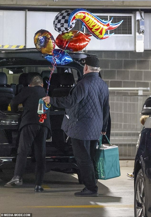 Pristupio je crnom bejzbol kapu i držao ruke punim vrućim kotačima balonima i torbom