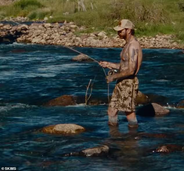 Umjetnik koji je oopćen, koji se čini da je entuzijastični na otvorenom, iskoristio je priliku da radi na svom preplanulu, dok je ribolovno bez koljena u par kratkih kratkih kratkih hlača dužine koljena