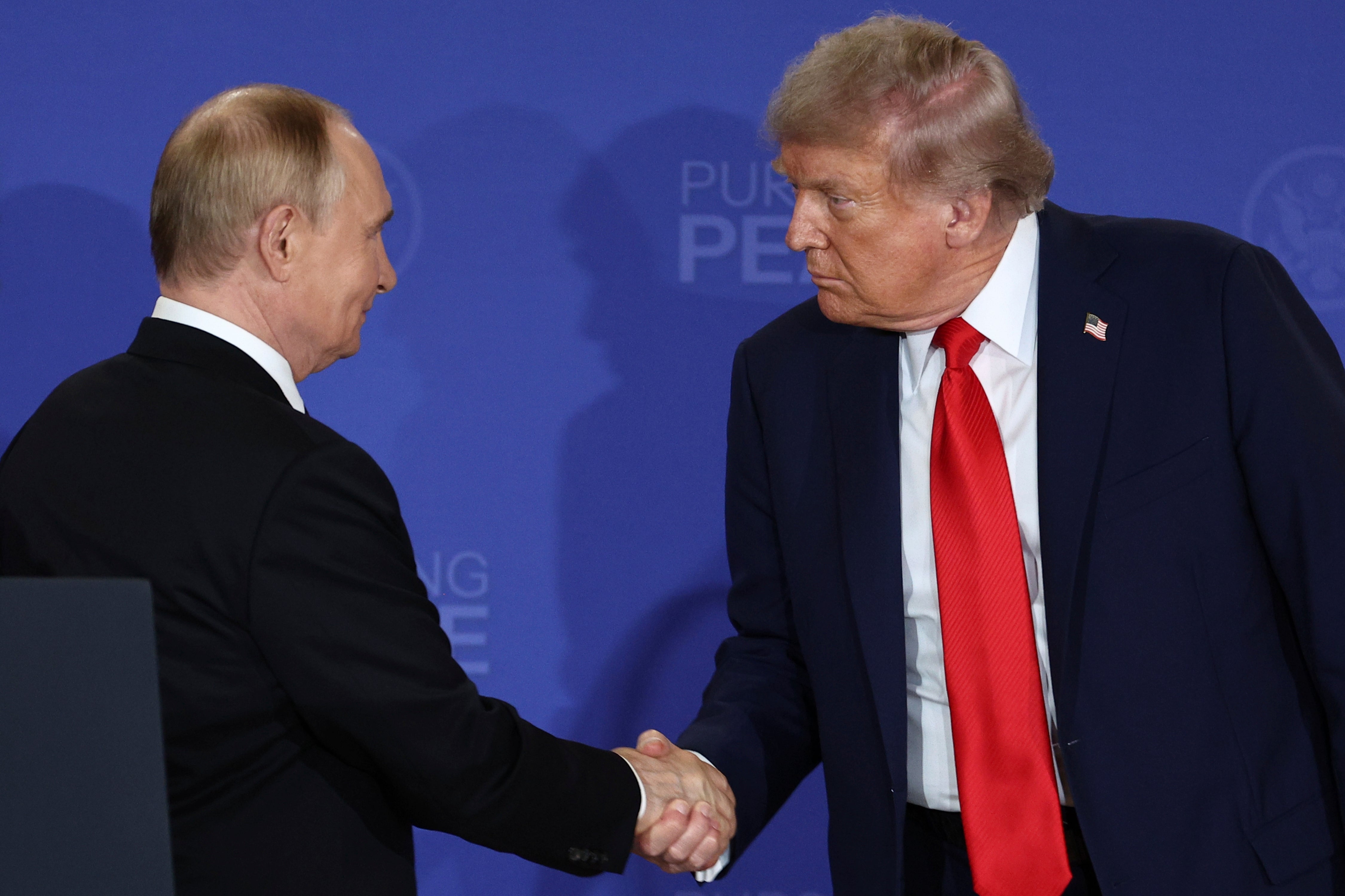 Donald Trump rukuje ruku Vladimira Putina (Sergej Bulkin, Sputnik, Kremljska fotografija bazena putem AP)
