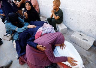 Majka palestinskog Mohammeda al-Motawaka, kojeg je ubijen izraelskim požarom dok je pokušavao primiti pomoć u nedjelju, prema medicinskim liječnicima, oplakuje nad njegovim tijelom tijekom pogreba u bolnici Al-Shifa, u gradu Gazi u gradu Gaza