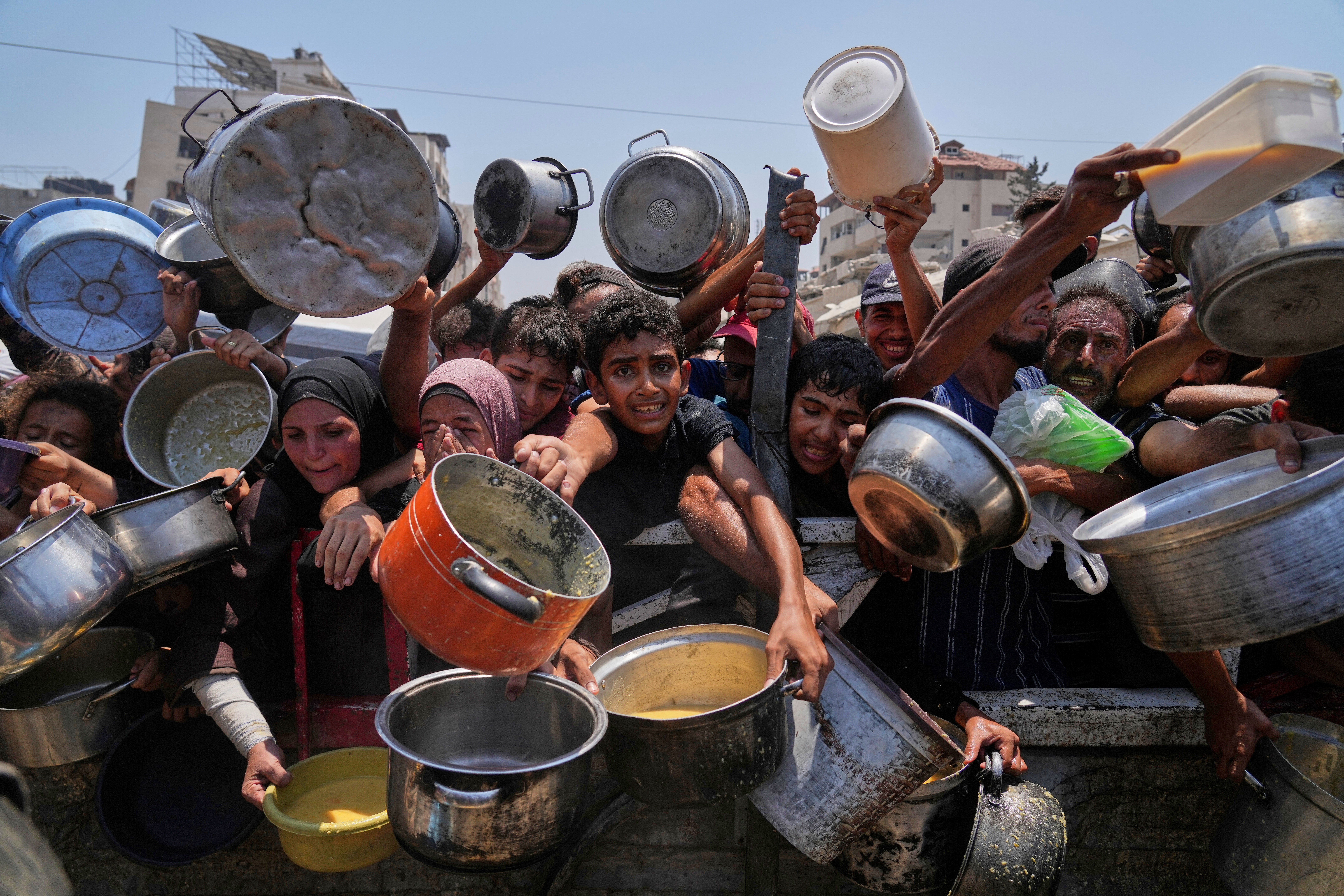 Palestinci se bore da dobiju doniranu hranu u kuhinji zajednice u gradu Gaza, Strip na sjeveru Gaze