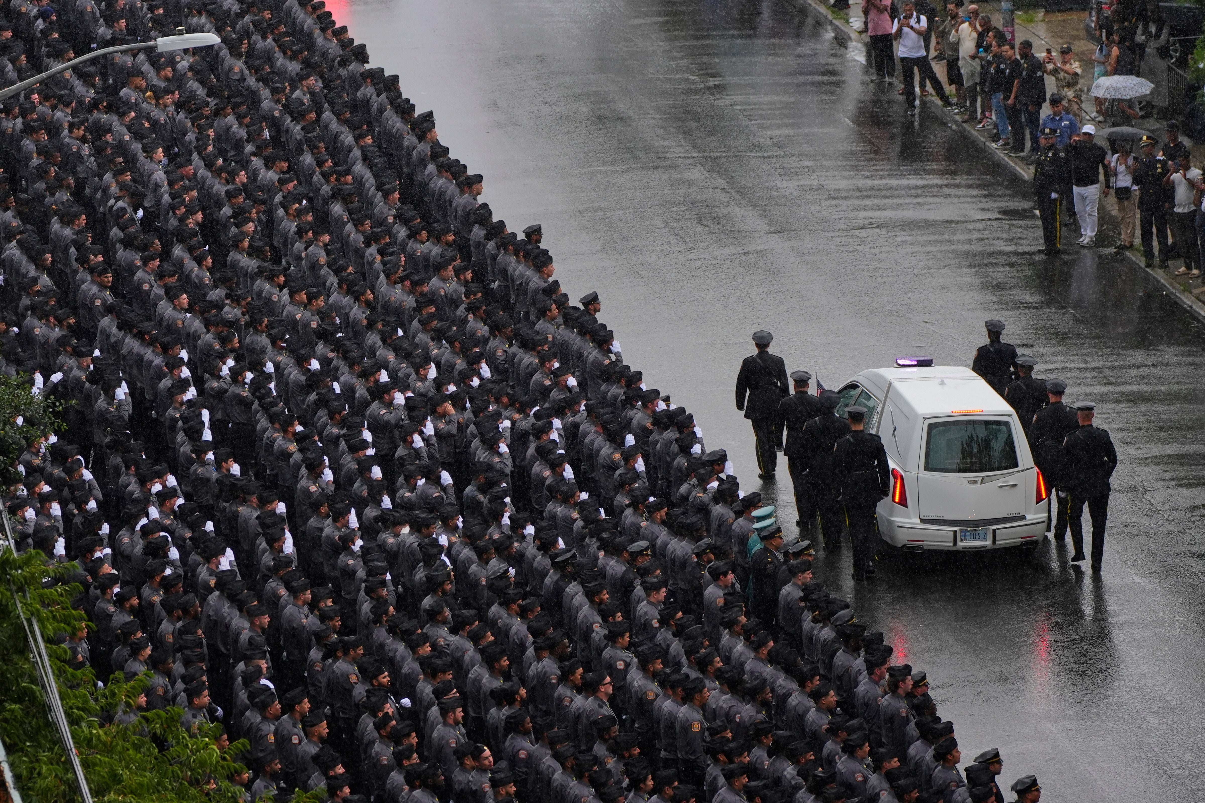 Njujorški policajci pozdravljaju dok je Hearse nosi kovčeg
