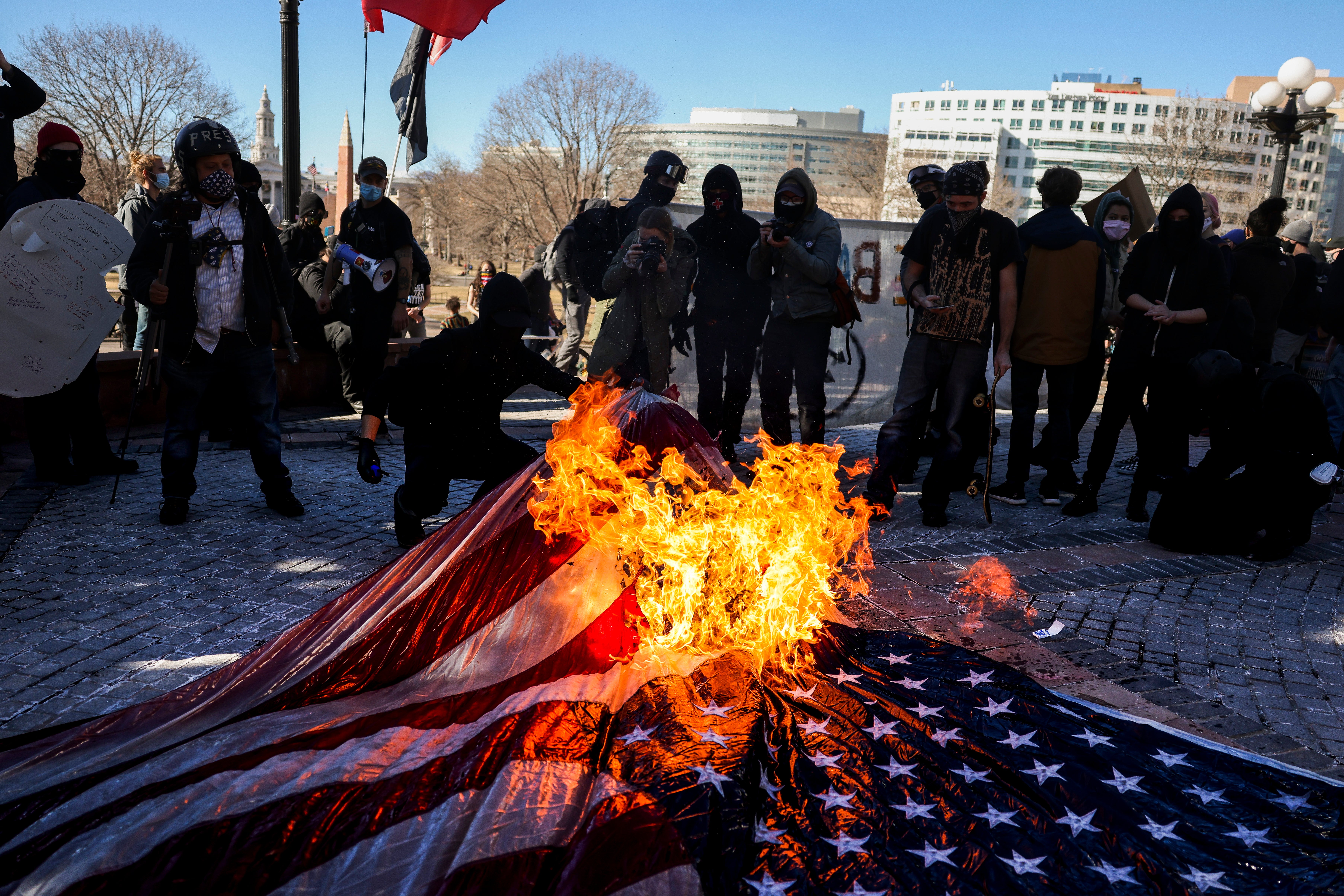 Prosvjednici spaljuju američku zastavu na demonstraciji u Denveru, Colo.