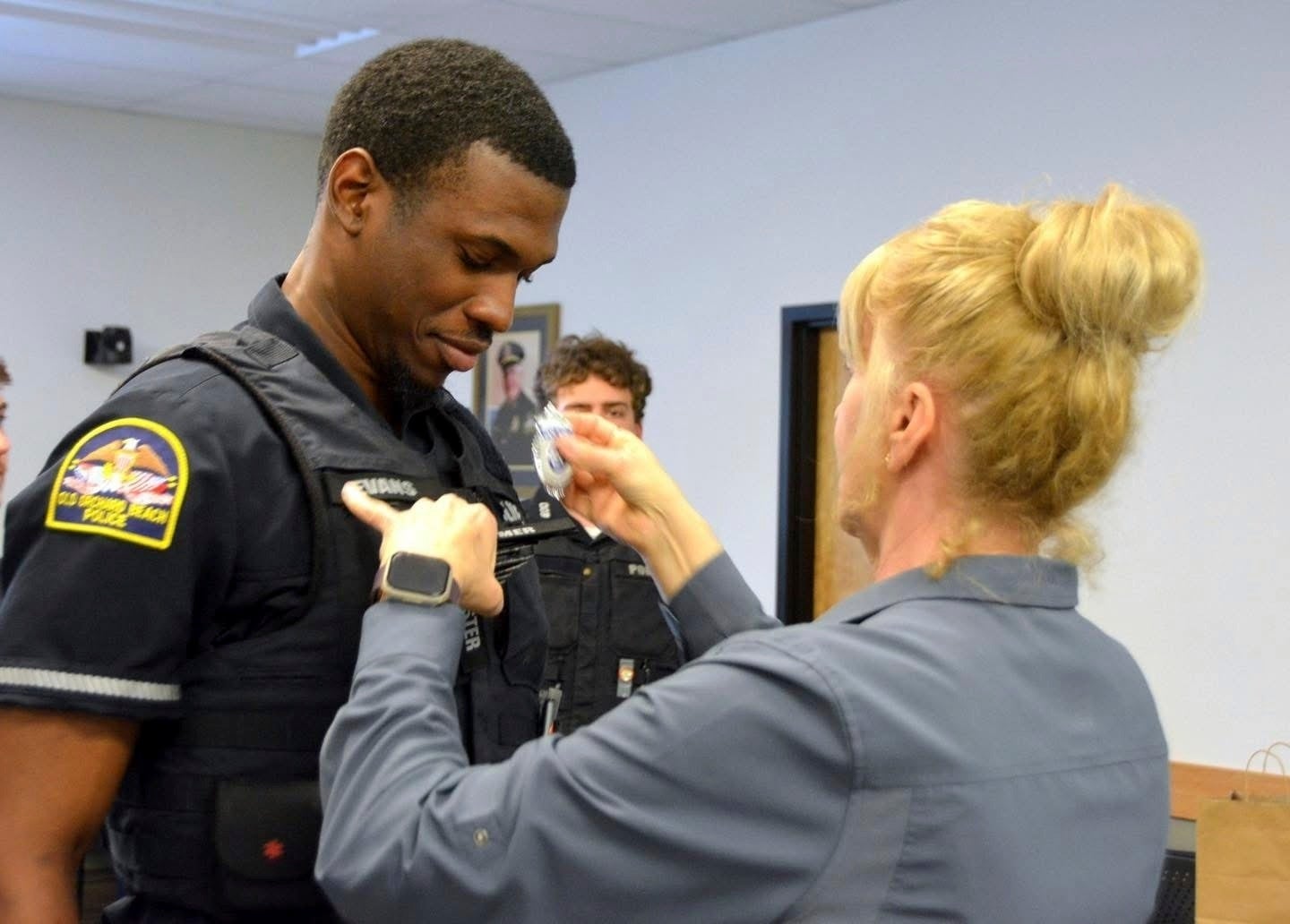 Policajac Jon Luke Evans prima svoju policijsku značku. DHS-ov sustav e-verify potvrdio je da je ovlašten raditi u SAD-u, priopćila je policijska uprava Old Orchard Beach, dok DHS kaže da je policijska uprava imala