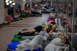 Ljudi se sklone unutar stanice metroa tijekom upozorenja o zračnom napadu usred ruskog napada na Ukrajinu