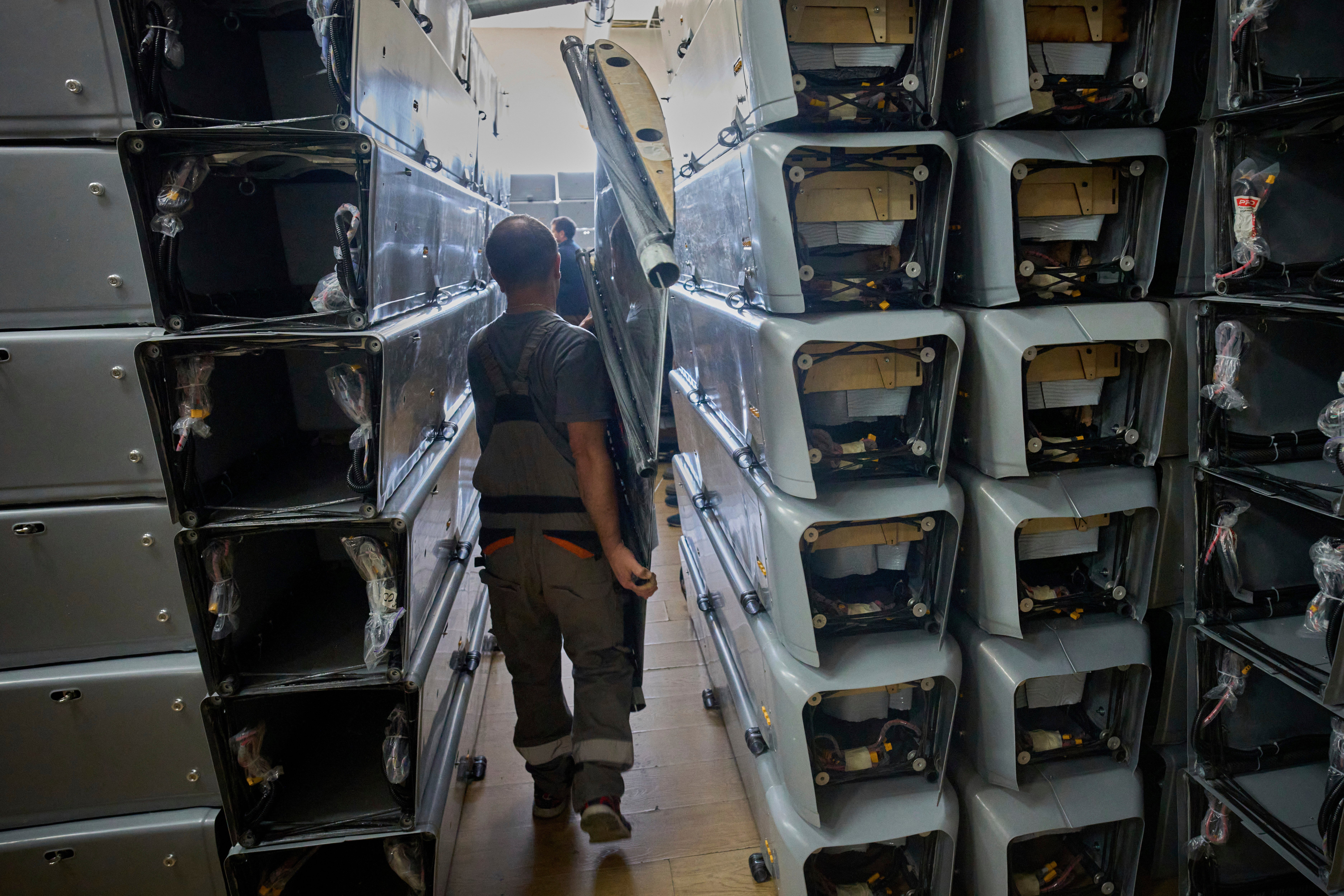 Radnik nosi dio borbenog drona u tvornici vatrene točke u Ukrajini