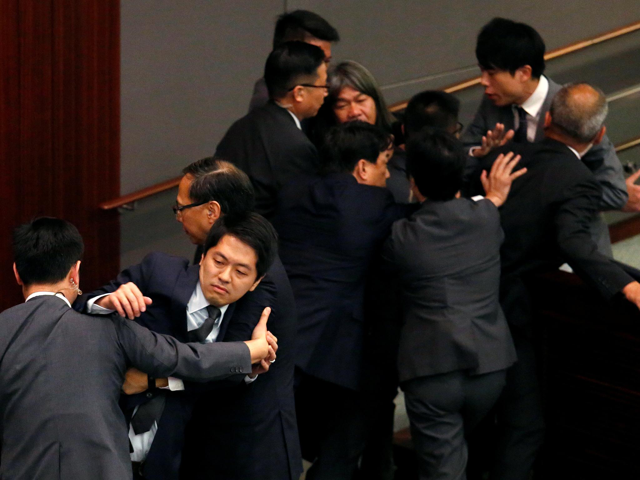 Zastupnici pro-demokracije Ted Hui i Leung Kwok-Hung blokirali su zaštitari dok pokušavaju zaustaviti postupak izabranog predsjednika vijeća u Zakonodavnom vijeću u Hong Kongu u Kini 2016. godine