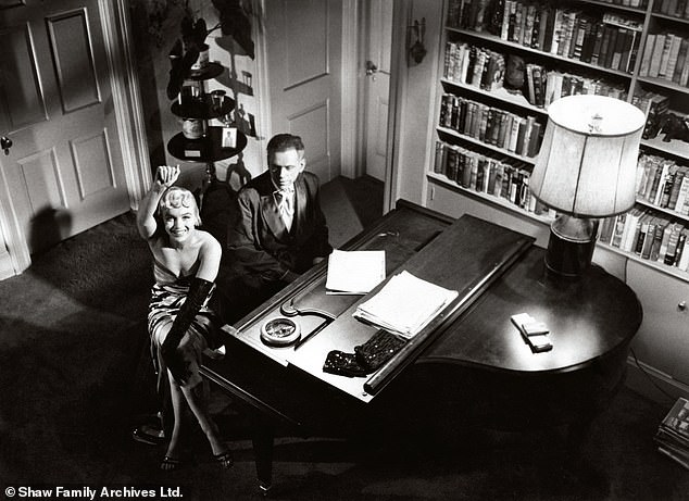 Monroe je sjedio na glasoviru sa zvijezdom Tomom Ewellom dok je mahao do Shawove kamere tijekom snimanja za sedmogodišnji svrbež 1954.