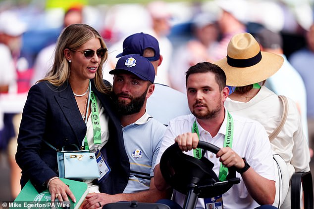 Kelley Cahill, supruga španjolskog golfera Jona Rahma, sjedi u krilu dok se javljaju na golf kolica