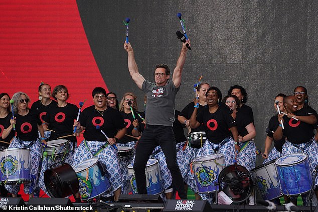 Zvijezda se sve osmjehnula dok se obratio gomili na događaju dok je bio obučen u sivu, grafičku košulju