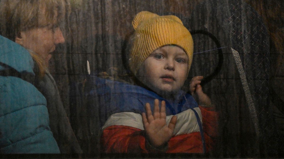 Ukrajinsko dijete pritiska ruku na prozor autobusa