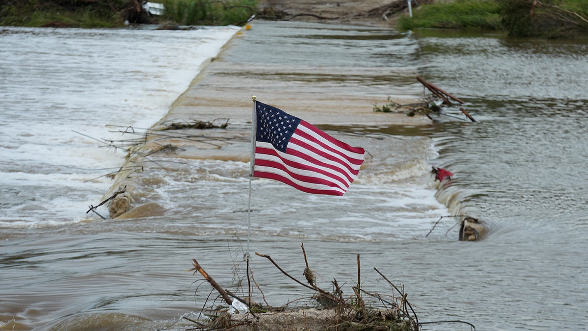 Poplavljena prometnica s američkom zastavom na rijeci Guadalupe u Teksasu