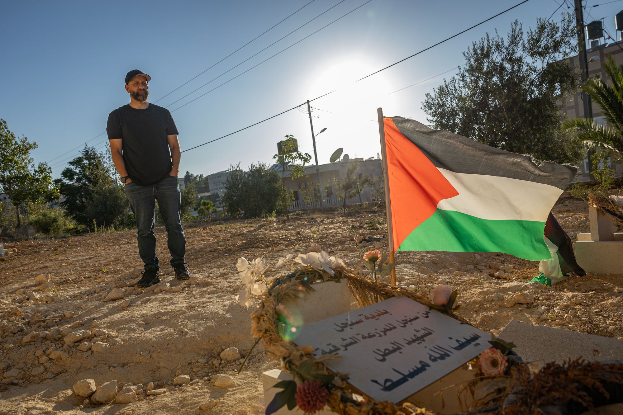 Kamel stands next to his son's grave after he was beaten to death by settlers in the occupied West Bank