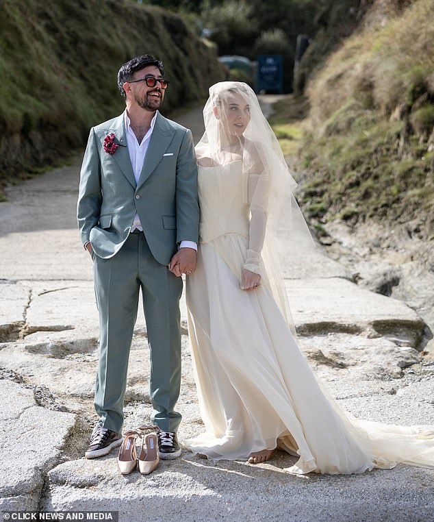 Ludo What Love može učiniti pjevačica izgledala je senzacionalno u korzetiranoj haljini s dugim rukavicama, suknjom i elegantnim velom, no bila je prisiljena ukloniti cipele u pijesku, dok se Charlie odlučila za trenere