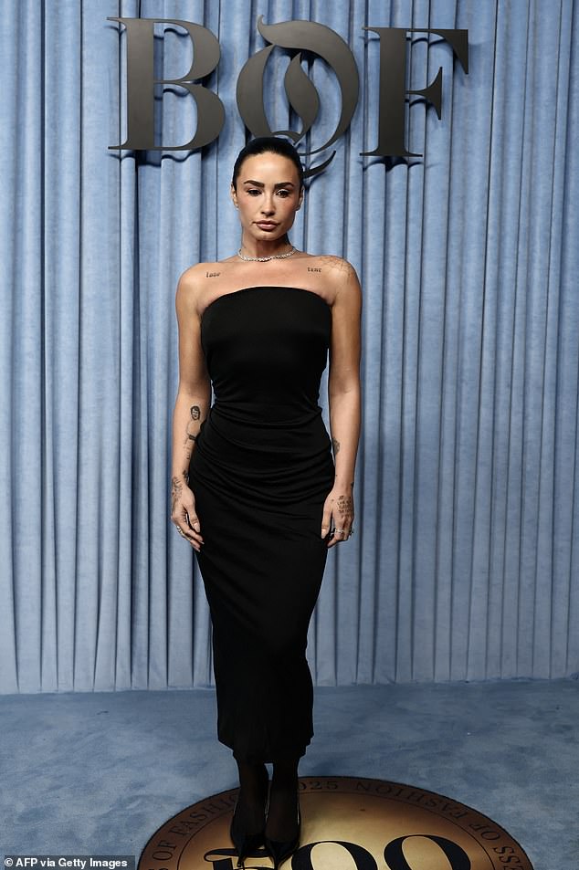 Demi Lovato bila je uzor šika, dok je ona preplavila svoju svečanu tjelesnost u crnoj crnoj haljini bez naramenica uparenom s čizama