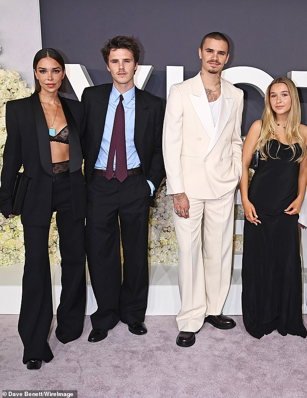 Dodala je centimetara svom okviru s visokim crnim platformama i nosila glatku crnu spojku dok je pozirala s klanom Beckham uoči projekcije (LR Jackie, Cruz, Romeo i Harper)