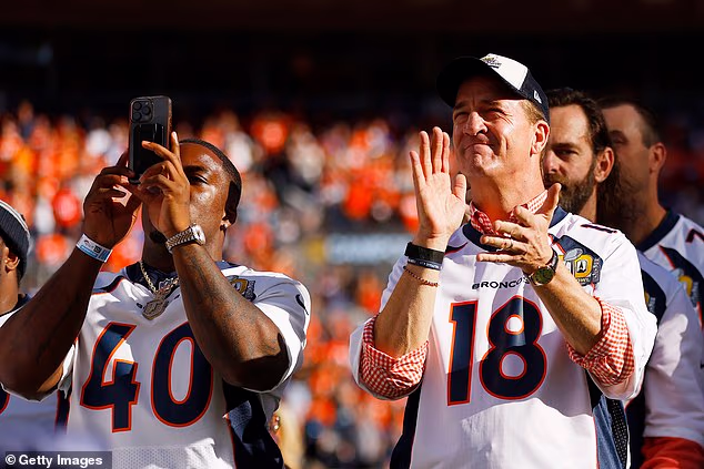 Bivši igrači Denver Broncosa Juwan Thompson i Peyton Manning plješću tijekom posthumnog predstavljanja Demaryiusa Thomasa u Prstenu slavnih Broncosa