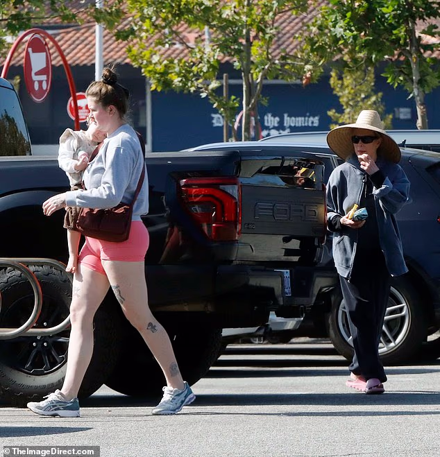 Basinger je držao sjajnu zelenu torbu; bio je to rijedak izlet za obitelj