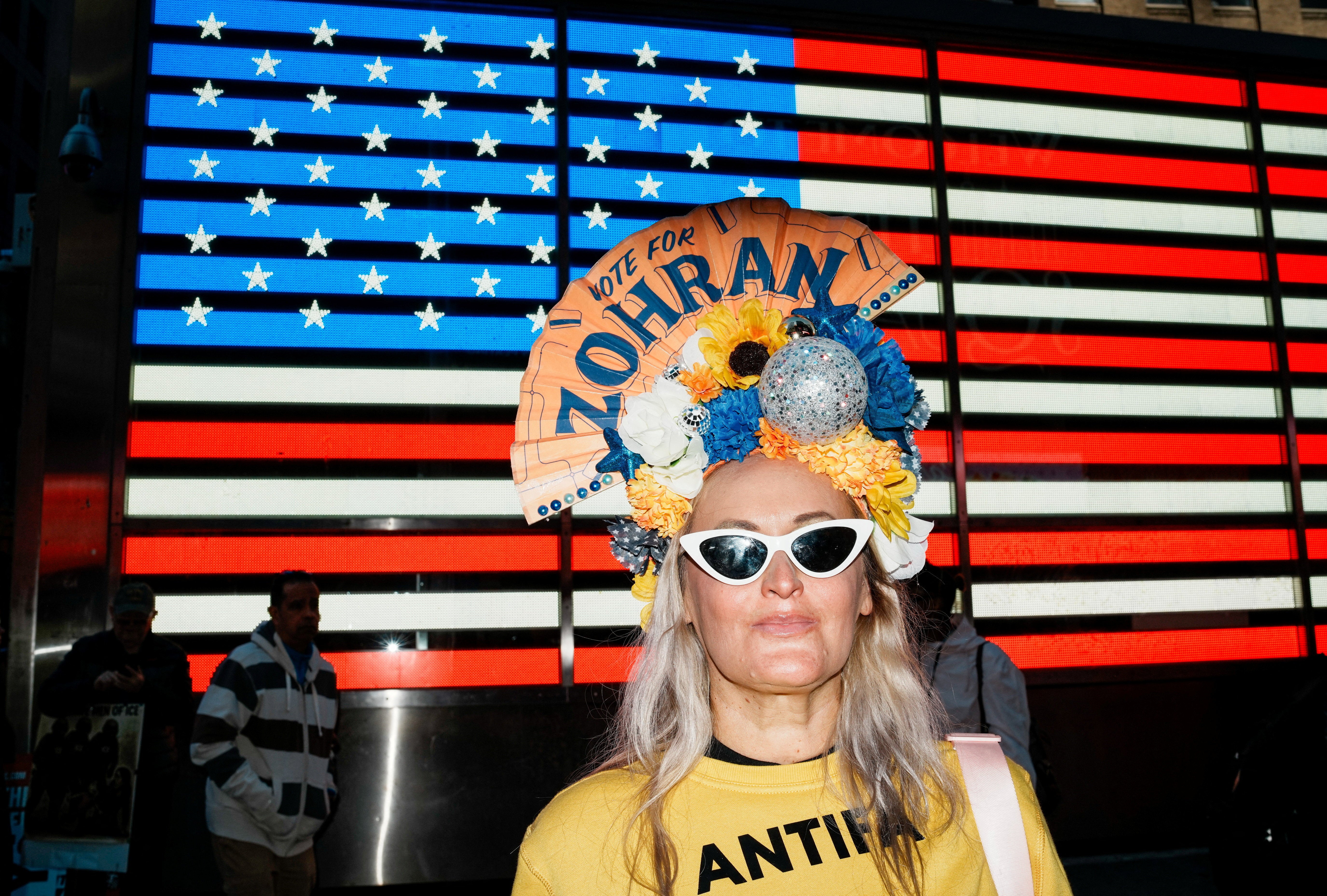 Žena u majici 'Antifa' i lepezom na glavi s porukom potpore kandidatu za gradonačelnika New Yorka Zohranu Mamdaniju