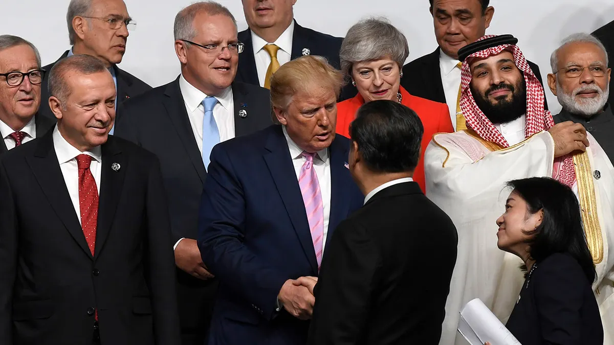 Predsjednik Donald Trump, u sredini, rukuje se s kineskim predsjednikom Xi Jinpingom, dok se okupljaju za grupnu fotografiju na summitu G-20 u Osaki, Japan, 28. lipnja 2019.