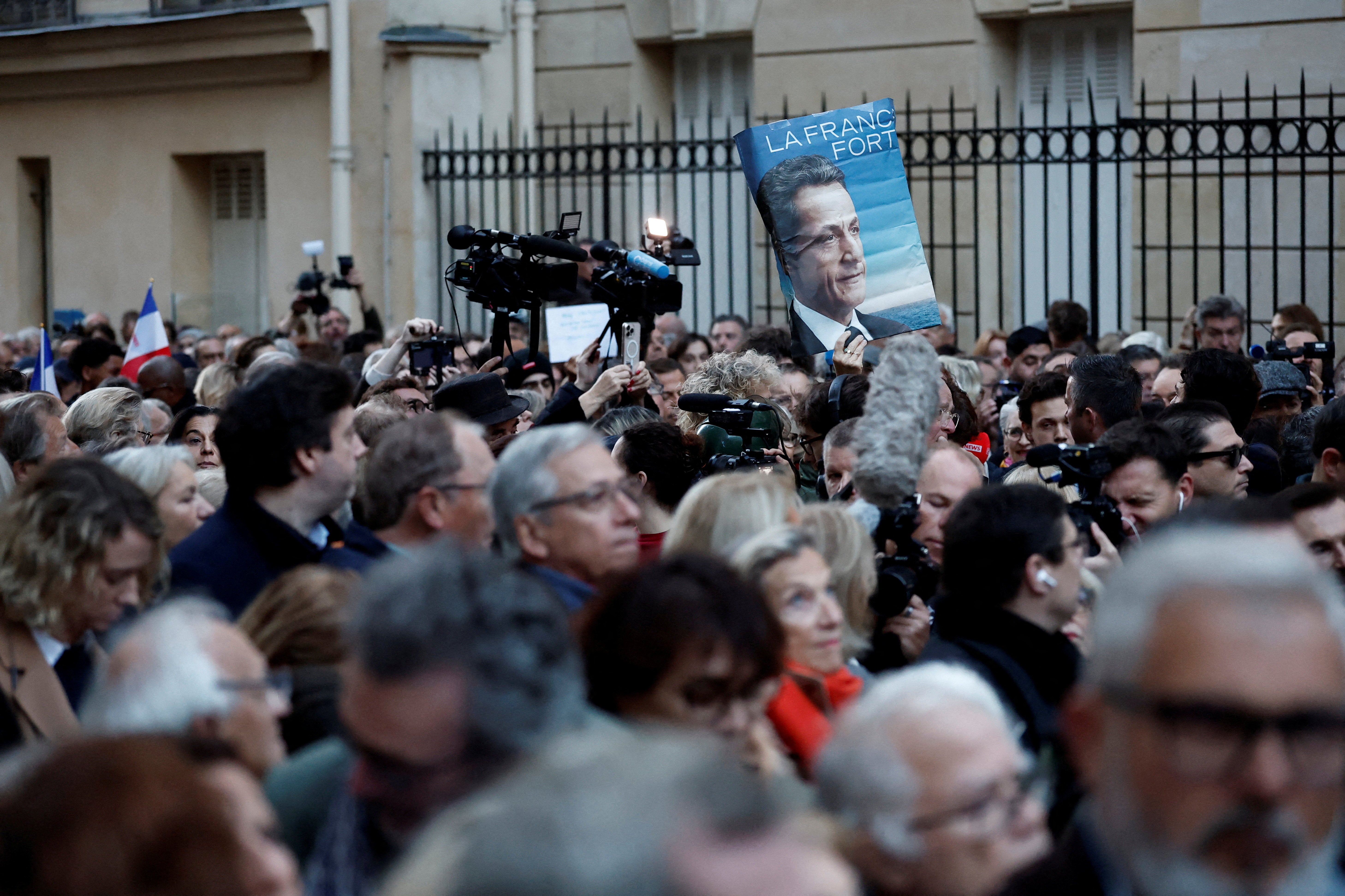 Pristaša drži plakat s portretom Nicolasa Sarkozyja i sloganom